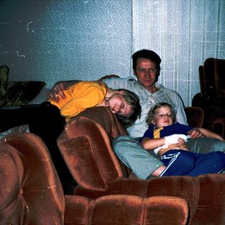 Family relaxing indoors watching television together.