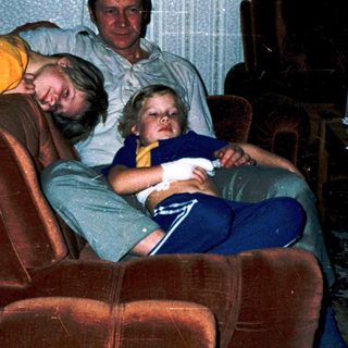 Family relaxing indoors watching television together.