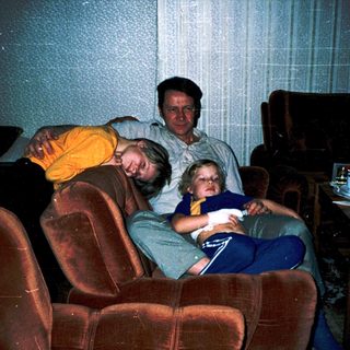 Family relaxing indoors watching television together.