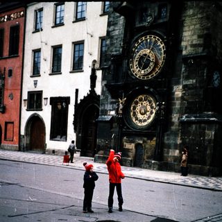 Historic astronomical clock in Prague Square with people observing.