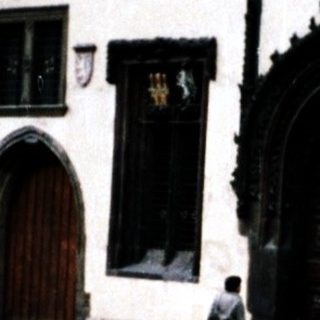 Historic astronomical clock in Prague Square with people observing.