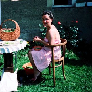Two people, including a child, dining outdoors under umbrella.