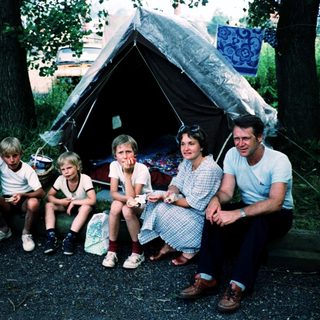 Family camping outdoors under a tent.