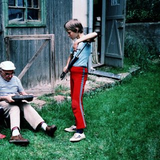 Three generations outdoors, reading and playing.