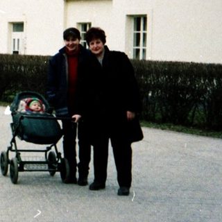 Family pushing stroller near observatory buildings.