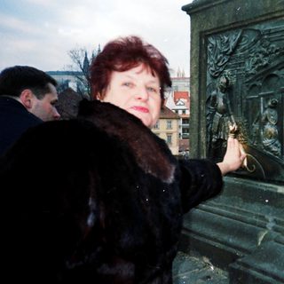 Woman lighting candle at memorial monument.