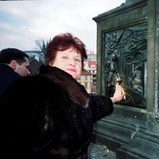 Woman lighting candle at memorial monument.
