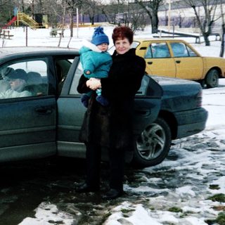 Family standing by snow-covered car in winter.