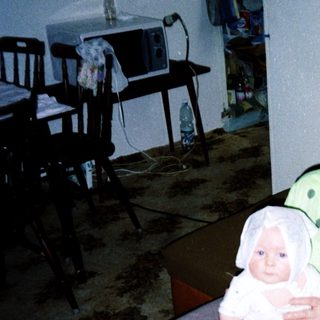 A woman holding a baby indoors.