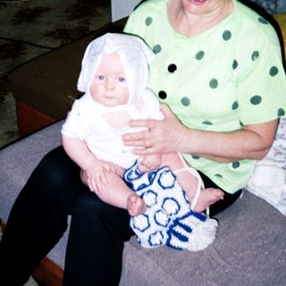 A woman holding a baby indoors.