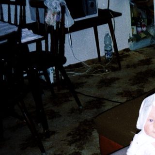 A woman holding a baby indoors.