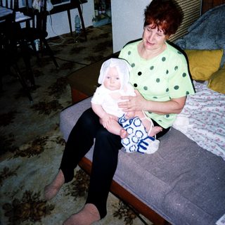 A woman holding a baby indoors.