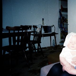 A woman holding a baby indoors.