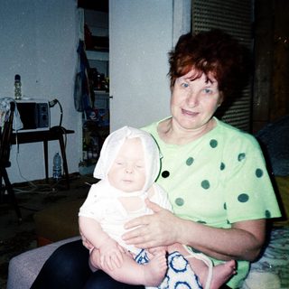 A woman holding a baby indoors.