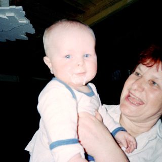 A person holding a baby in a dimly lit room.