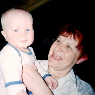 A person holding a baby in a dimly lit room.