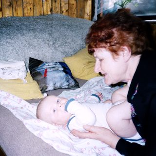 Woman breastfeeding baby on a couch.