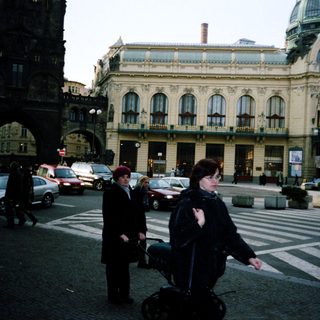 Urban street scene with historic building and pedestrians.