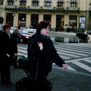 Urban street scene with historic building and pedestrians.