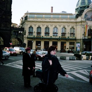 Urban street scene with historic building and pedestrians.