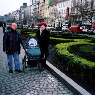Couple pushing stroller on city street.