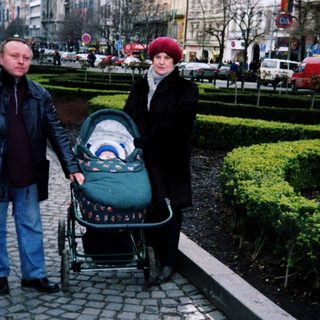 Couple pushing stroller on city street.