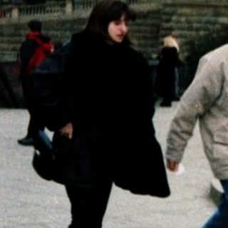 People walking near Prague Castle and statue.