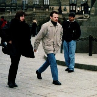 People walking near Prague Castle and statue.
