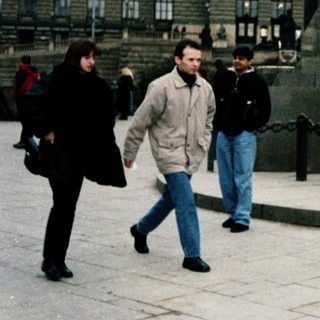 People walking near Prague Castle and statue.