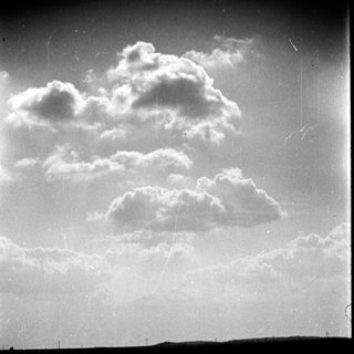 Fluffy clouds in a partly cloudy sky.