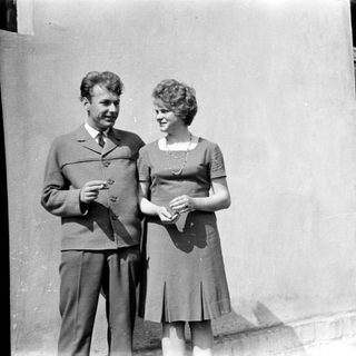 Couple posing together outdoors in vintage clothing.