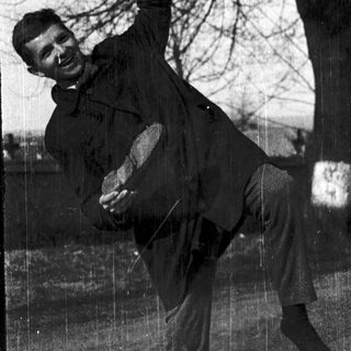 Man joyfully swinging a heavy object outdoors.