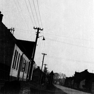 Flooded rural street with submerged buildings and power lines.