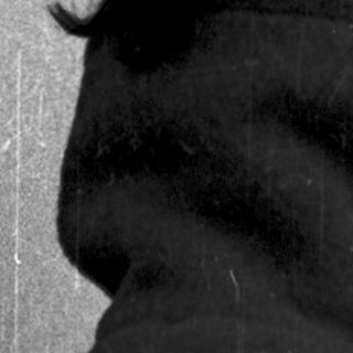 Silhouette of person wearing hooded coat against rain.