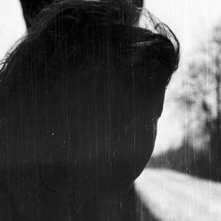 Silhouette of person looking out in rain.