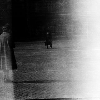 Blurred figures walking in rain or snow.