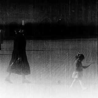 Blurred figures walking in heavy rain.