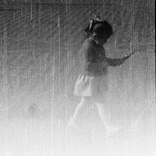 Blurred figures walking in heavy rain.
