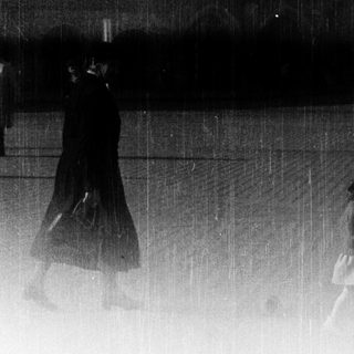 Blurred figures walking in heavy rain.