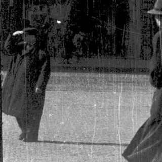 Vintage street scene with people walking in rain.
