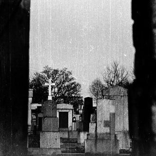 Gothic-style cemetery with tombs and trees.