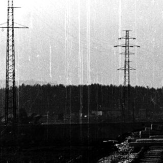 Railroad tracks with long freight train cars.