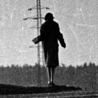 Person walking alone on railway tracks.
