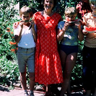 Family posing outdoors with watermelons.