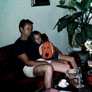 Family indoors with teddy bear, enjoying a relaxed moment.