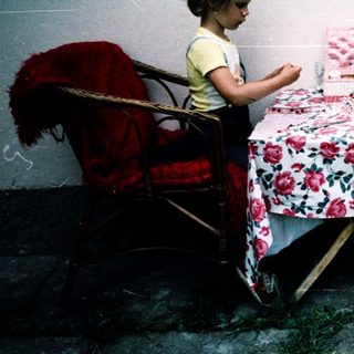 Two adults and a child crafting outdoors.
