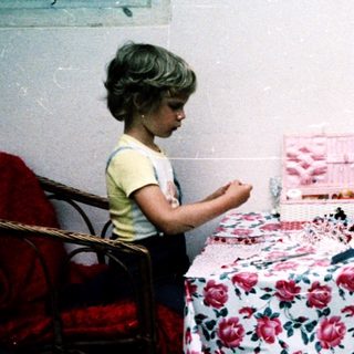 Two adults and a child crafting outdoors.