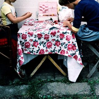 Two adults and a child crafting outdoors.