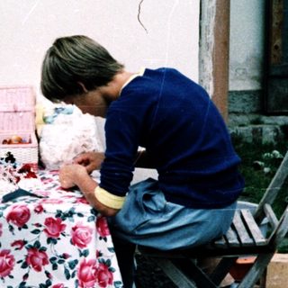 Two adults and a child crafting outdoors.