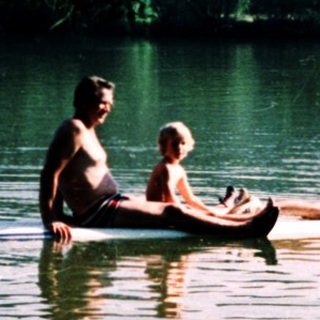 Two people relaxing on a small boat in calm water.
